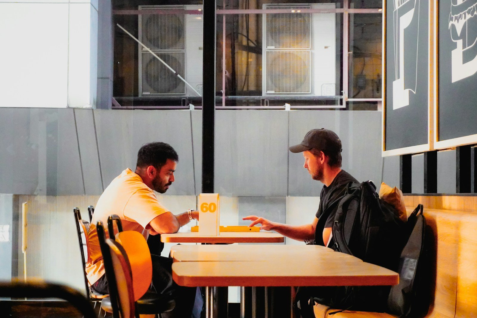 Two people seated across a cafe table in conversation