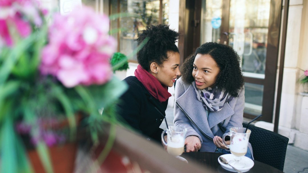 Two friends talking at an outdoor cafe table